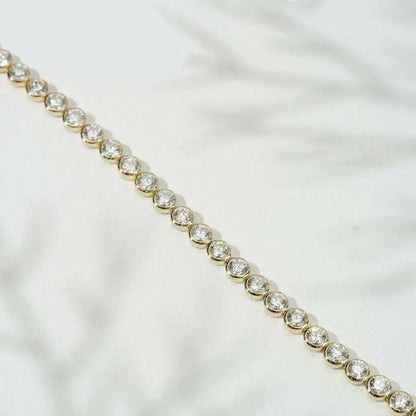 Pulsera de tenis de oro amarillo de 18 quilates con engaste de bisel y cadena de tenis con diamantes redondos DEF VS cultivados en laboratorio.